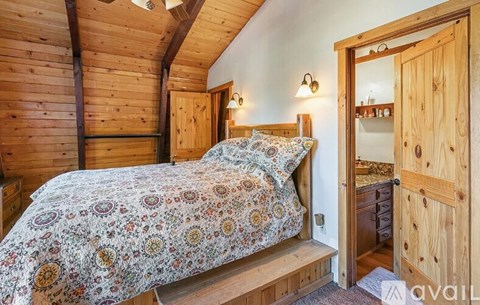 A bedroom with a bed and a wooden dresser.