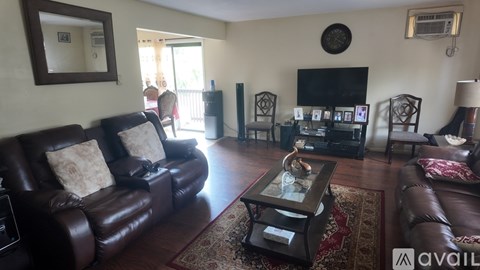A living room with brown leather furniture and a fireplace.