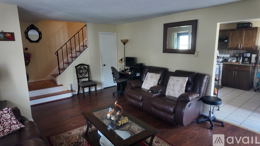 A living room with a brown leather couch and a coffee table.