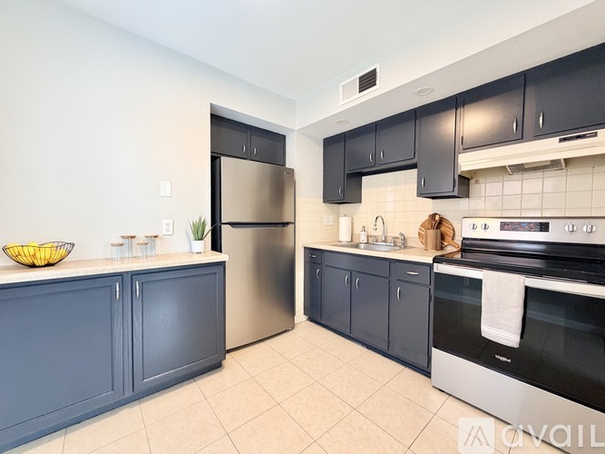 A kitchen with a refrigerator, oven, and sink.