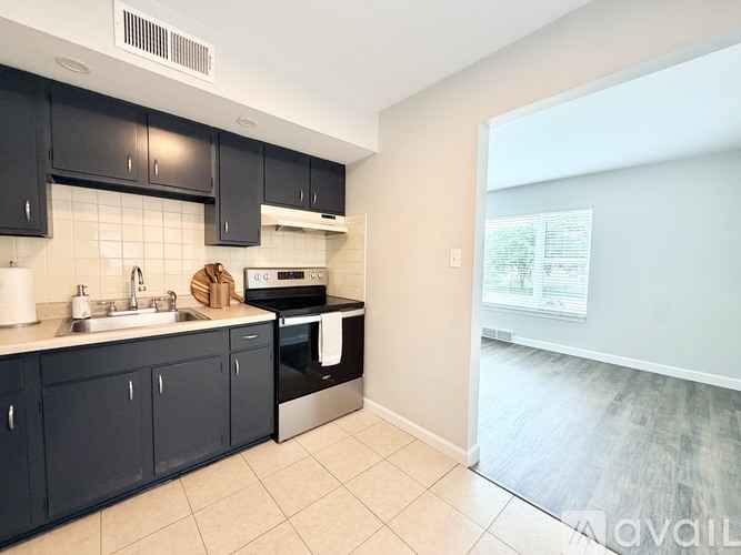 A kitchen with black cabinets and a white sink.