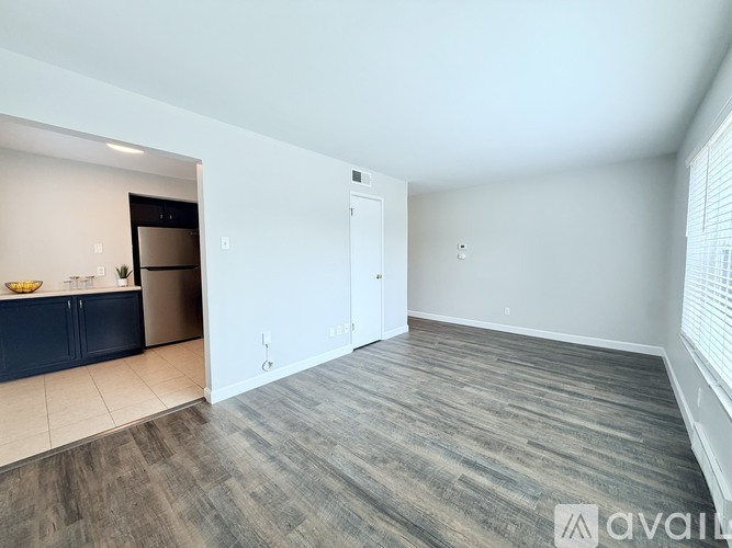 A spacious room with a doorway leading to another room.