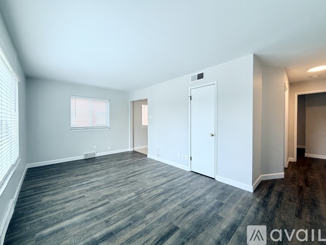 A spacious room with a grey carpet and white walls.