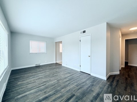 A spacious room with a grey carpet and white walls.