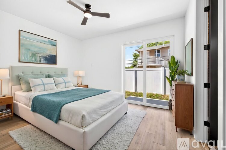 A bedroom with a large bed and a ceiling fan.