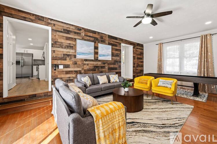 A living room with a grey couch and yellow chairs.