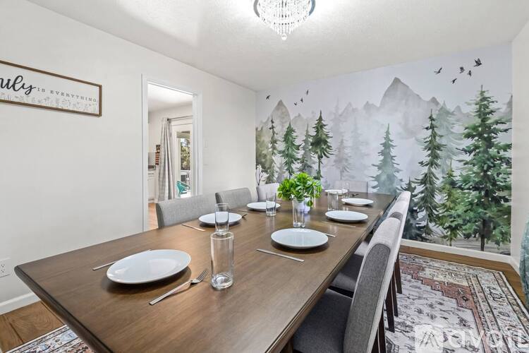 A dining room with a wooden table set for four.