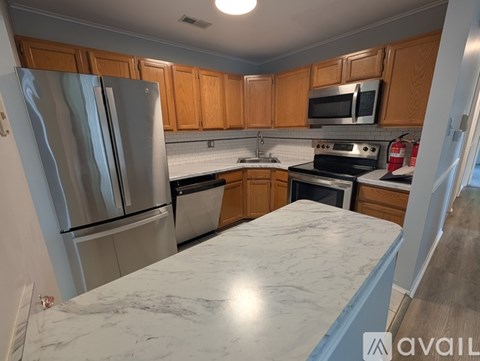 A kitchen with wooden cabinets and a marble countertop.