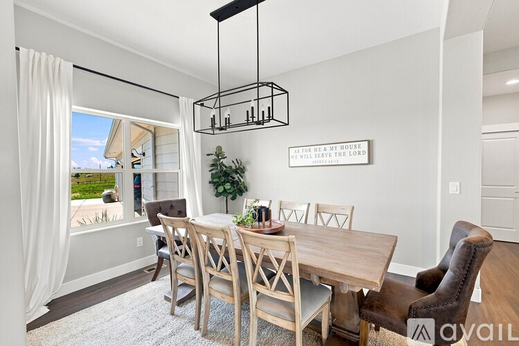 A dining room with a wooden table and chairs.