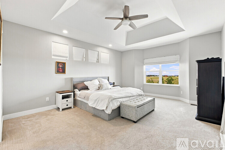 A bedroom with a large bed and a ceiling fan.