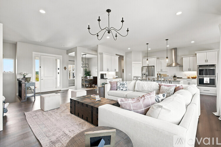 A modern living room with a white couch and a chandelier.