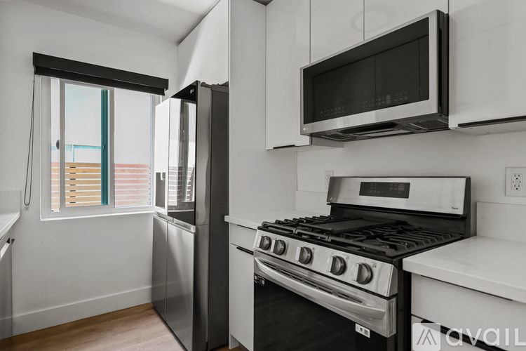 A modern kitchen with a stainless steel refrigerator, oven, and microwave.