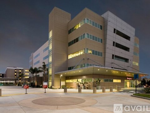 A modern building with a circular driveway in front.