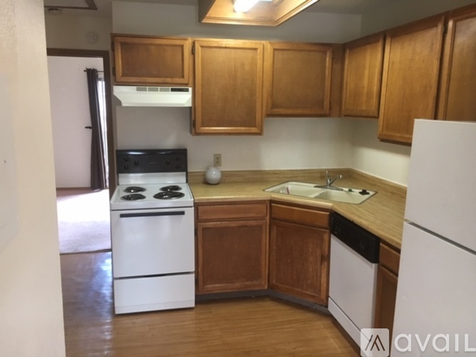 A kitchen with wooden cabinets and a white fridge.