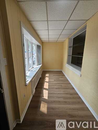 A long hallway with wooden floors and white walls.