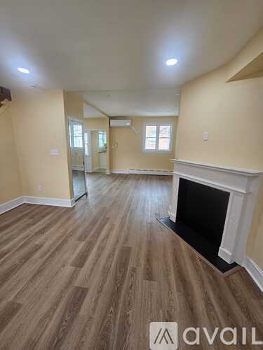 A living room with a fireplace and wood flooring.
