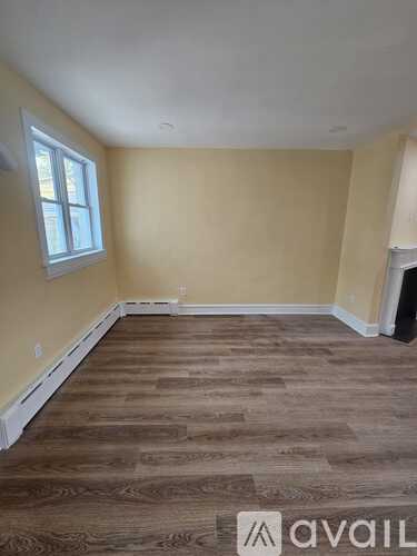 A room with wooden flooring and a window.