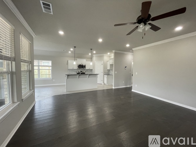 A spacious room with a ceiling fan and wooden flooring.