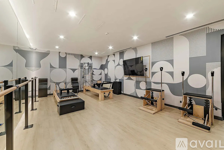A gym with a variety of equipment including weights and a bench.