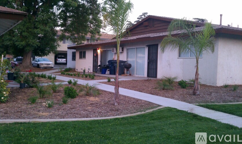 A house with a white fence and a tree in front of it.