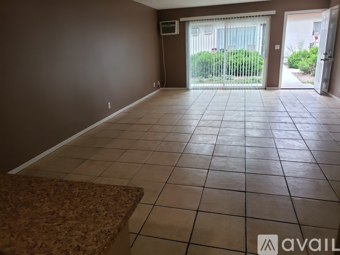 A room with brown walls and a tiled floor with a rug in the foreground.