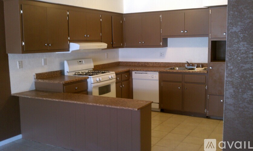 A kitchen with brown cabinets and a white stove top oven.