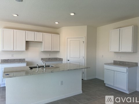 A kitchen with white cabinets and a marble countertop.