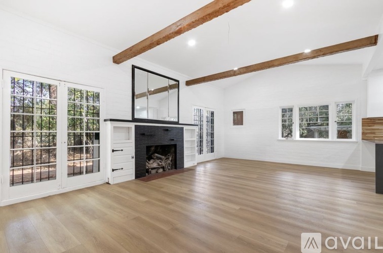 A spacious living room with a fireplace and large windows.