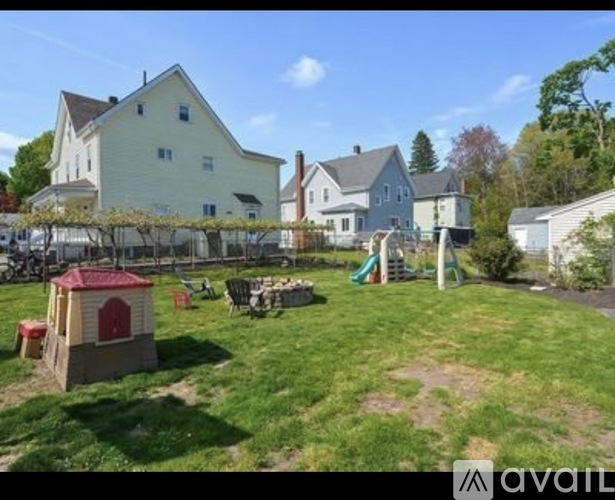 A backyard with a playground and a dog house.