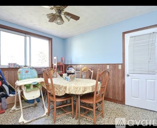 A dining room with a table and chairs.