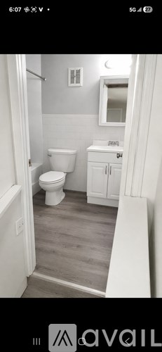 A bathroom with a toilet, sink, and mirror.