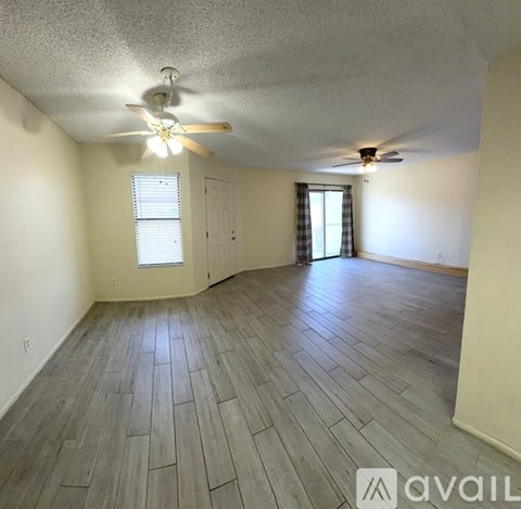 A room with a ceiling fan and a window with blinds.