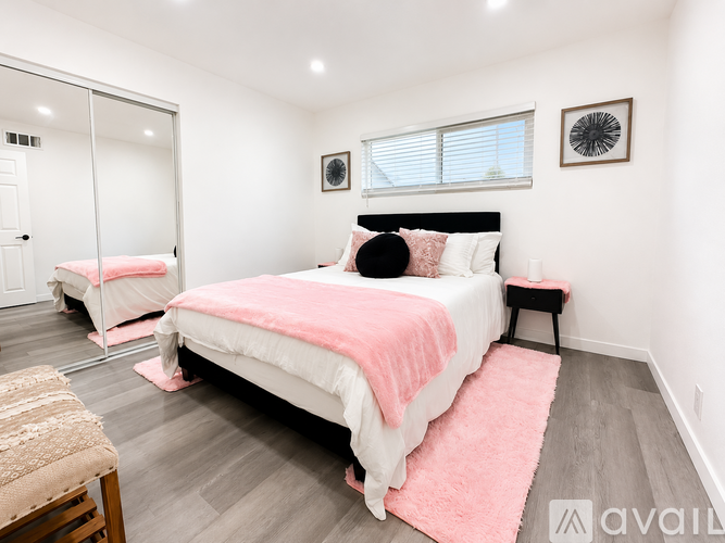 A bedroom with a large bed and a mirror on the wall.