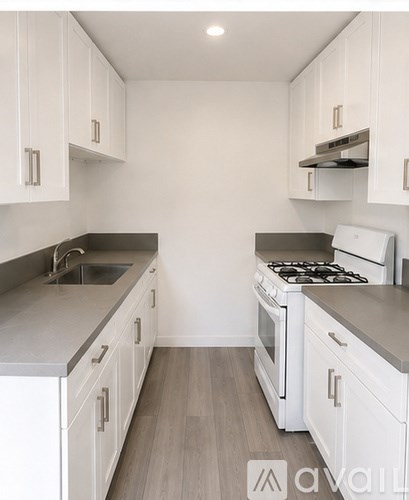 A kitchen with white cabinets and a stove top oven.