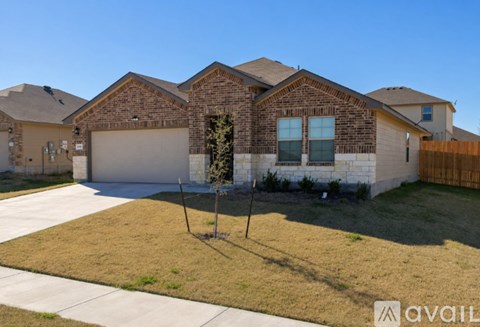 A house with a brown brick exterior and a white garage door.