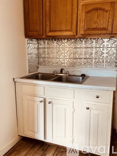 A kitchen with a sink and wooden cabinets.