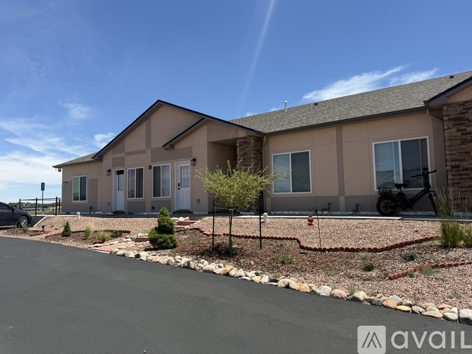 A house with a brown roof and tan walls is for sale.