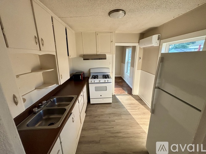A kitchen with white cabinets and a white stove top oven.