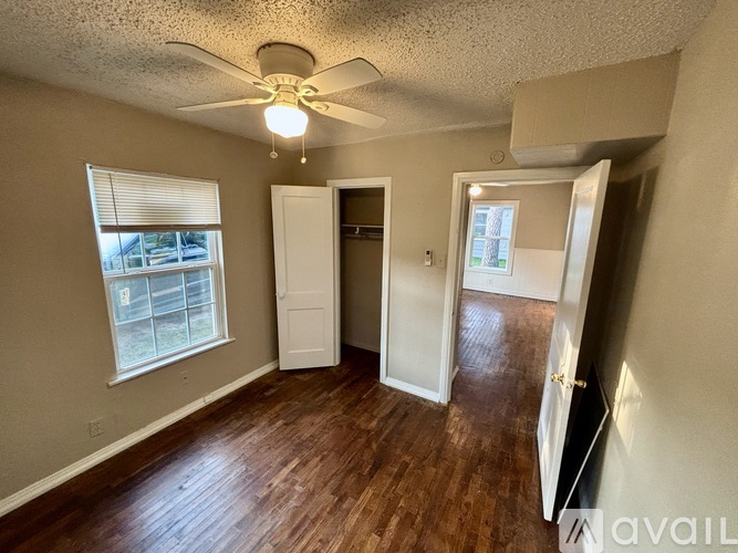 A room with a ceiling fan and wooden floors.