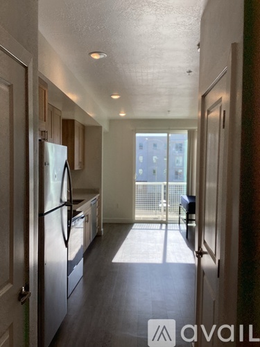 A kitchen with a refrigerator and a dining table.