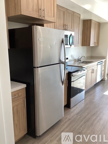 A kitchen with a white fridge and wooden cabinets.