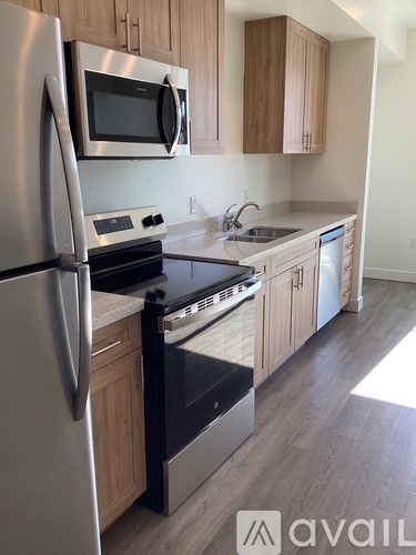A kitchen with a stainless steel refrigerator, microwave, oven, and sink.