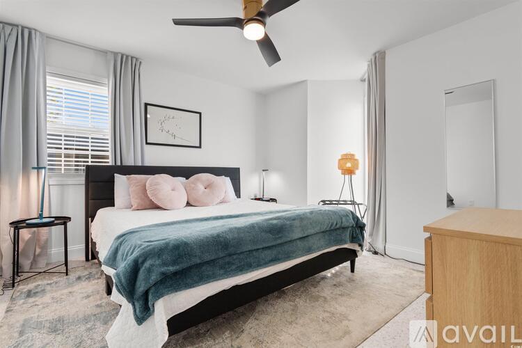 A bedroom with a large bed and a ceiling fan.