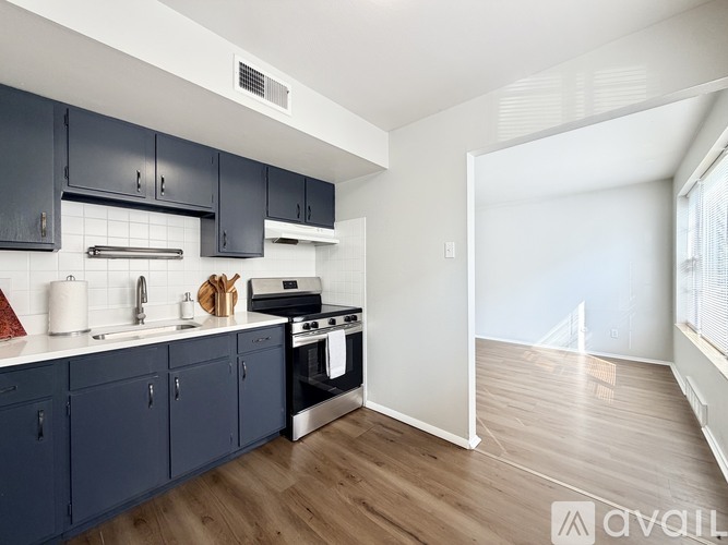 A kitchen with dark blue cabinets and a white countertop.