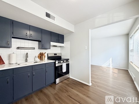 A kitchen with dark blue cabinets and a white countertop.