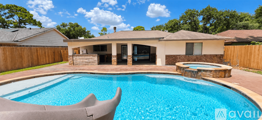 A pool in a backyard with a house in the background.