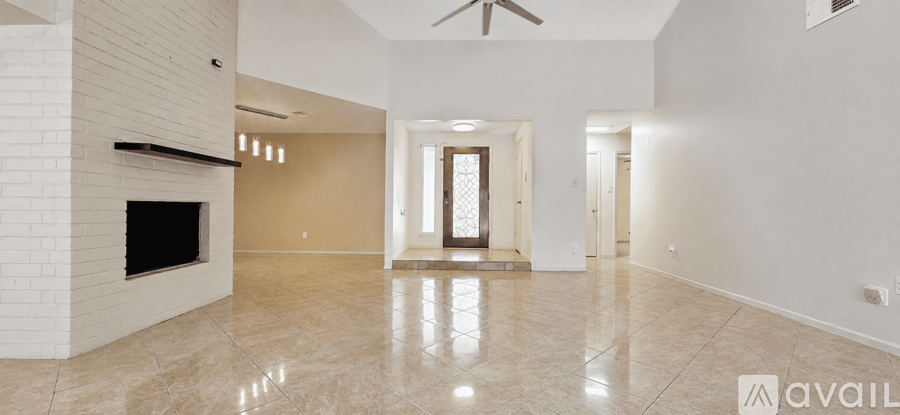 A spacious living room with a fireplace and a large mirror on the wall.