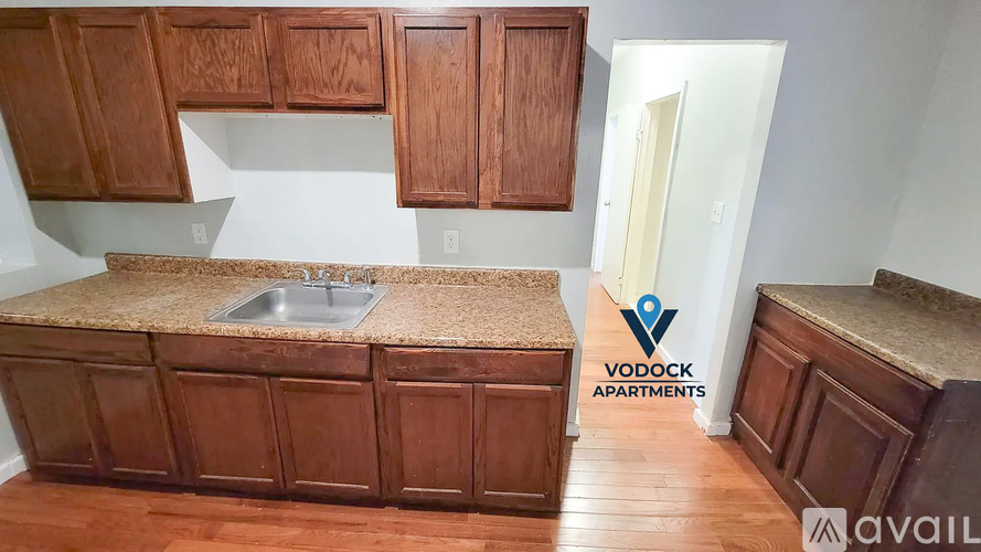 A kitchen with wooden cabinets and a countertop is available for rent.