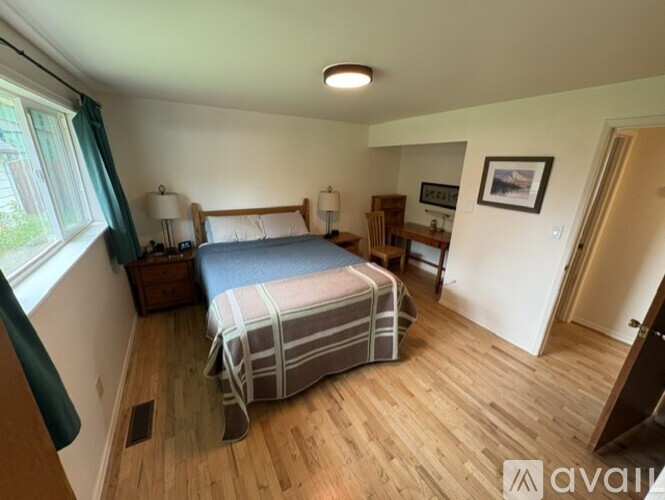 A bedroom with a bed, nightstand, and chair.