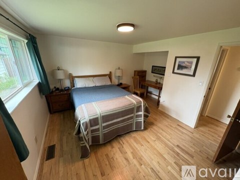 A bedroom with a bed, nightstand, and chair.